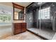 Main bathroom with dark tile walk in shower, stone floors and vanity at 1211 E Pointe Dr, Durham, NC 27712