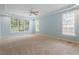 Light-filled main bedroom with tray ceiling, ceiling fan, and large windows at 1211 E Pointe Dr, Durham, NC 27712