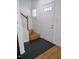 Bright entryway featuring a white door, staircase, and a combination of tile and wood flooring at 1402 Barton Place Dr, Raleigh, NC 27608