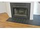 Image of a fireplace with a black tile surround and hearth in a home with wood and tile flooring at 1402 Barton Place Dr, Raleigh, NC 27608