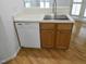 Kitchen sink area with stainless steel sink, wood cabinets, and white dishwasher at 1402 Barton Place Dr, Raleigh, NC 27608