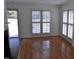 Bright living room with hardwood floors, shutters, and a view to an outdoor entrance at 1402 Barton Place Dr, Raleigh, NC 27608