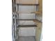 Image of a storage area with empty wooden shelves against a light-colored wall with pipes and conduits at 1402 Barton Place Dr, Raleigh, NC 27608