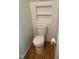 Bathroom featuring a toilet with wooden floors, a built-in wall shelf, and toilet paper holder at 1402 Barton Place Dr, Raleigh, NC 27608