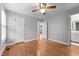 Bedroom with hardwood floors, neutral walls, ceiling fan, and a view into the connected bathroom at 1731 Malone Rd # A, Burlington, NC 27215