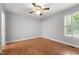 Simple bedroom with hardwood floors, neutral walls, ceiling fan, and bright window lighting at 1731 Malone Rd # A, Burlington, NC 27215