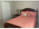 Bedroom features a comfy bed with pink bedding, a small side table and lamp, and closet at 1913 Rendall St, Burlington, NC 27215