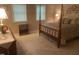 Cozy bedroom with a four poster bed, neutral walls, and two bright windows with blinds at 1913 Rendall St, Burlington, NC 27215