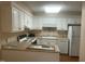 Bright kitchen featuring white cabinetry, modern appliances, and a breakfast bar for casual dining at 1913 Rendall St, Burlington, NC 27215