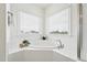 Bright bathroom featuring a soaking tub beneath two windows, tile surround, and chrome fixtures at 200 Cloud Berry Ln, Holly Springs, NC 27540
