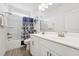 Bright bathroom with a double sink vanity, tile floors, and shower with patterned curtain at 200 Cloud Berry Ln, Holly Springs, NC 27540