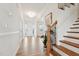 Bright entryway featuring hardwood floors, decorative glass on the front door, and an elegant staircase at 200 Cloud Berry Ln, Holly Springs, NC 27540