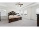 Spacious main bedroom with a large bed, ceiling fan, tray ceiling and lots of natural light at 200 Cloud Berry Ln, Holly Springs, NC 27540