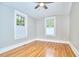 Light-filled bedroom with hardwood floors and two windows offering scenic views at 2031 Englewood Ave, Durham, NC 27705