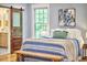 Charming bedroom featuring a sliding barn door, cozy blue quilt, and decorative art at 2031 Englewood Ave, Durham, NC 27705