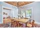 Spacious dining room with wood ceiling, chandelier, large windows, and a table with six chairs at 2031 Englewood Ave, Durham, NC 27705