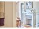 Close up of a fireplace with white mantle, gray tile surround, and hardwood floors, seen from hallway at 2031 Englewood Ave, Durham, NC 27705