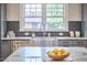 Stainless steel farmhouse sink with stone countertop, dark backsplash, and view through the kitchen window at 2031 Englewood Ave, Durham, NC 27705