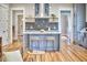 Spacious kitchen with island, pendant lighting, gray cabinetry, stainless appliances, and hardwood floors at 2031 Englewood Ave, Durham, NC 27705