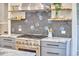Updated kitchen featuring marble countertops, gray cabinets, stainless steel range, and floating wood shelves at 2031 Englewood Ave, Durham, NC 27705