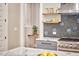 Open kitchen featuring marble countertops, gray cabinets, stainless steel range, and floating wood shelves at 2031 Englewood Ave, Durham, NC 27705