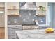 Bright kitchen features modern appliances, a stainless range hood, gray cabinets, and marble countertops at 2031 Englewood Ave, Durham, NC 27705