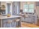 Modern kitchen with island, bar seating, marble countertops, stainless steel appliances, and hardwood floors at 2031 Englewood Ave, Durham, NC 27705