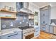 Modern kitchen with stainless steel appliances, sleek gray cabinets, marble countertops, and custom tile backsplash at 2031 Englewood Ave, Durham, NC 27705