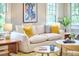 Sun-drenched living room featuring a plush sofa with decorative pillows and charming decor provides a welcoming space at 2031 Englewood Ave, Durham, NC 27705