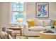 Bright living room featuring a comfortable sofa with decorative pillows, a stylish side table, and a large window at 2031 Englewood Ave, Durham, NC 27705