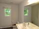 Clean and bright bathroom features two large windows, sink, toilet and mirror at 2039 Alderman Way, Creedmoor, NC 27522