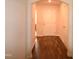 Hallway with dark laminate flooring, arched doorway, closet door, and view of the home's entrance at 2039 Alderman Way, Creedmoor, NC 27522