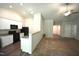 Open kitchen showcases white cabinets, black appliances, half wall and dark plank flooring at 2039 Alderman Way, Creedmoor, NC 27522