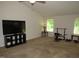 Spacious living room with large TV, carpet flooring, and plenty of natural light at 2039 Alderman Way, Creedmoor, NC 27522