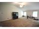 Unstaged living room featuring a large ceiling fan, a large window, and carpeted flooring at 2039 Alderman Way, Creedmoor, NC 27522