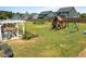 Large backyard featuring a pergola, garden, and playground, perfect for outdoor activities at 204 Ashland Hill Dr, Holly Springs, NC 27540