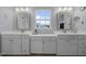 Bathroom featuring double sink vanity, framed mirrors, and window views at 204 Ashland Hill Dr, Holly Springs, NC 27540