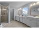 Bathroom featuring double sink vanity, framed mirrors, and walk-in shower at 204 Ashland Hill Dr, Holly Springs, NC 27540