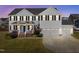 Beautiful two-story home with a well-maintained lawn, black shutters, and three-car garage at 204 Ashland Hill Dr, Holly Springs, NC 27540