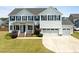 Beautiful two-story home with a well-maintained lawn, black shutters, and three-car garage at 204 Ashland Hill Dr, Holly Springs, NC 27540