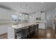 Bright kitchen featuring a large island with bar seating, granite countertops, and white cabinetry at 204 Ashland Hill Dr, Holly Springs, NC 27540