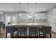 Kitchen featuring a large central island with bar stools, white cabinetry and stone countertops at 204 Ashland Hill Dr, Holly Springs, NC 27540