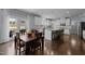Open-concept kitchen featuring white cabinets, granite countertops, stainless steel appliances, and hardwood floors at 204 Ashland Hill Dr, Holly Springs, NC 27540