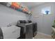 Well-equipped laundry room with modern washer, dryer, utility sink, and shelving at 204 Ashland Hill Dr, Holly Springs, NC 27540