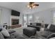 Cozy living room features plush sofas, stone fireplace, and a ceiling fan at 204 Ashland Hill Dr, Holly Springs, NC 27540