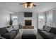 Comfortable living room with plush sofas, a stone fireplace, and a ceiling fan at 204 Ashland Hill Dr, Holly Springs, NC 27540