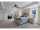 Spacious bedroom features tray ceilings, neutral walls, ceiling fan, bedside tables, and decor at 204 Ashland Hill Dr, Holly Springs, NC 27540