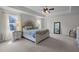 Spacious bedroom features tray ceilings, neutral walls, ceiling fan, and bedside tables with lamps at 204 Ashland Hill Dr, Holly Springs, NC 27540