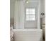 Bright and modern bathroom featuring white curtains and a luxurious soaking tub at 207 N Aiken St, Fuquay Varina, NC 27526