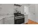 Modern kitchen with marble backsplash, stainless steel oven, and custom cabinetry at 207 N Aiken St, Fuquay Varina, NC 27526